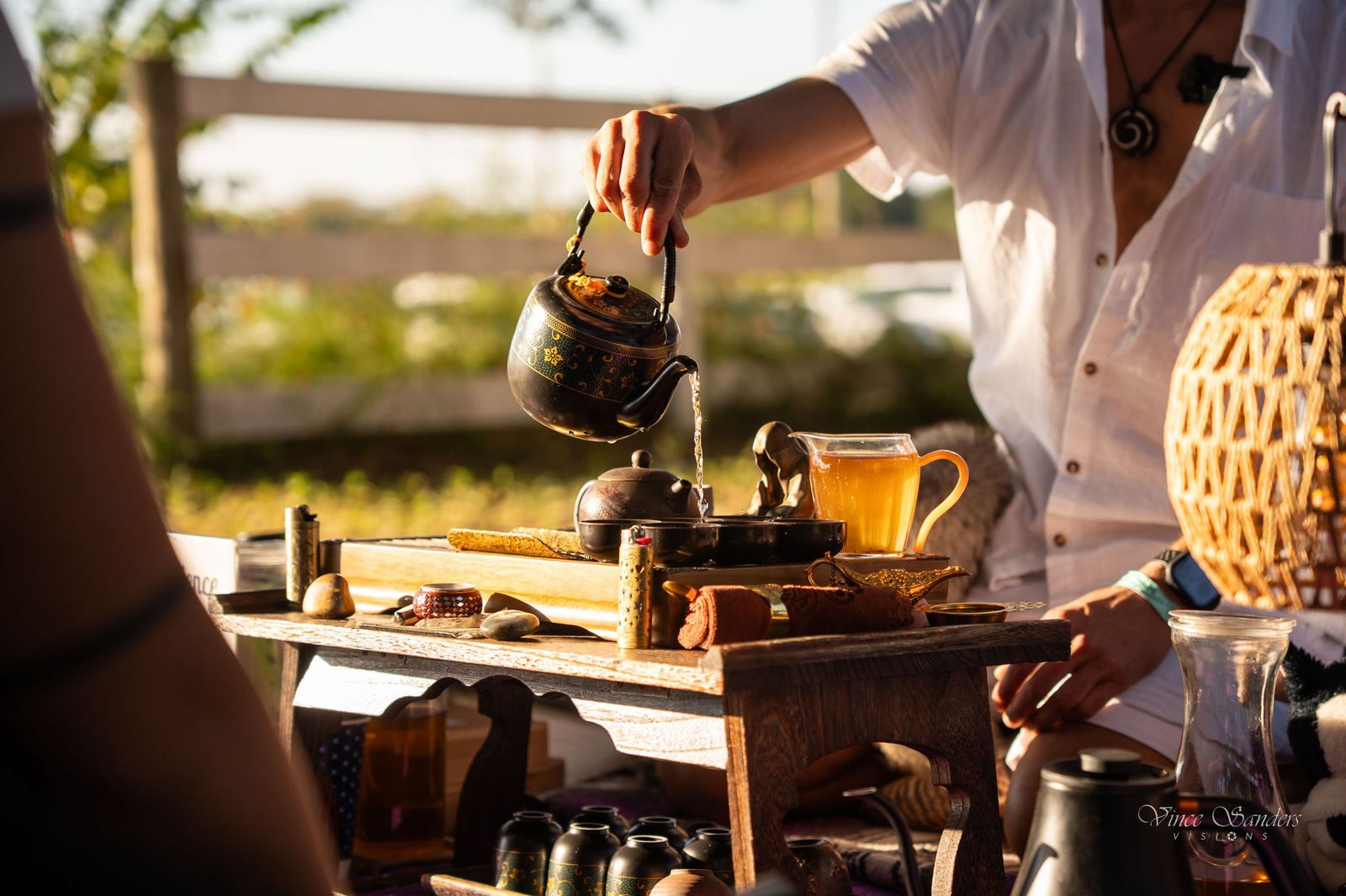 Jake pouring tea outdoors in golden afternoon light